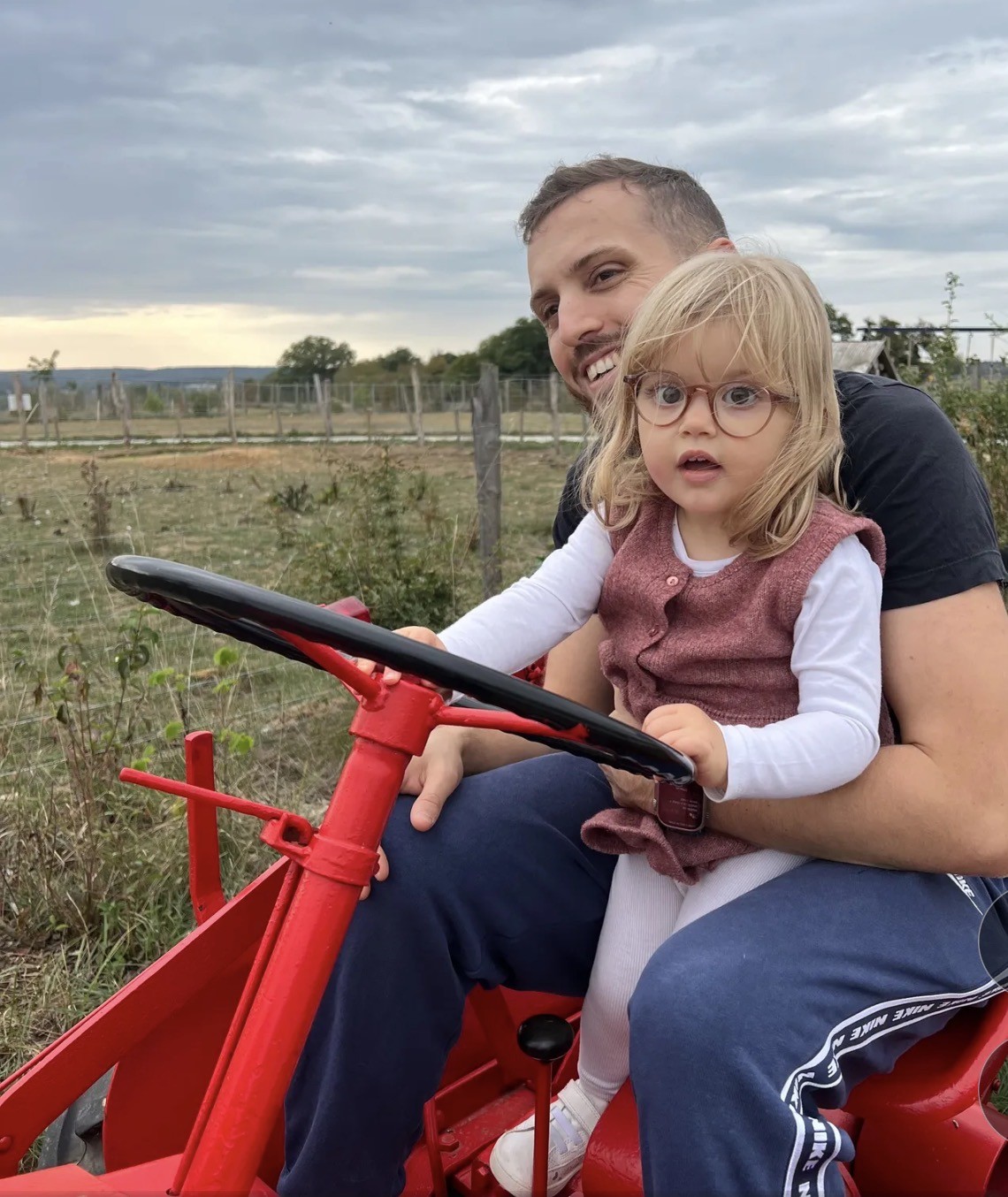 Anna au volant d’un tracteur, installée avec son papa.