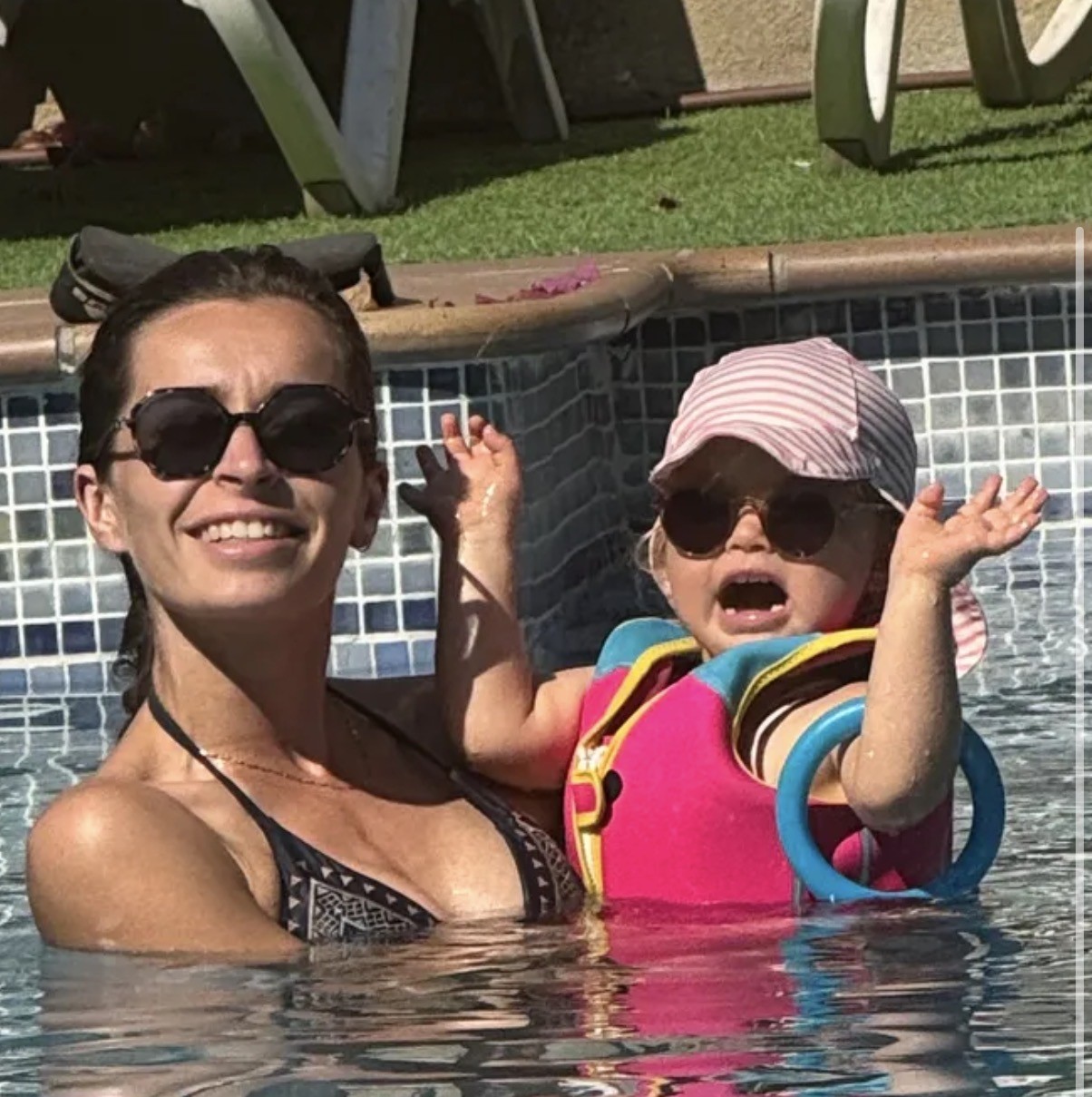Anna et sa maman dans une piscine, avec lunettes de soleil.